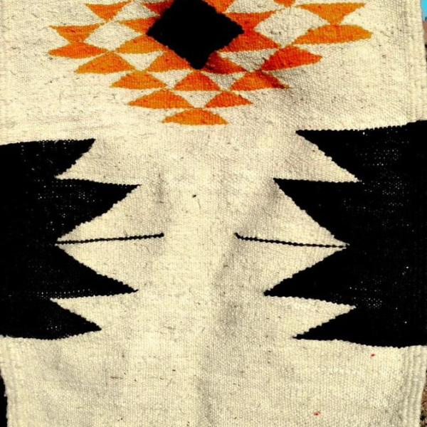 Tapis berbère écru avec motifs géométriques noirs et orange